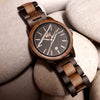 WILD ROCK RK30N – Montre en santal noir et noyer avec cadran en marbre noir dans une mise en scène sur pierre