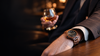 Montre en bois Wild portée au poignet d’un homme dans une ambiance élégante et chaleureuse